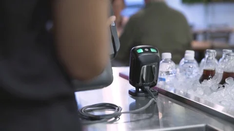 Dolly shot of wait staff using machinery while customer paying bill through Stock Footage