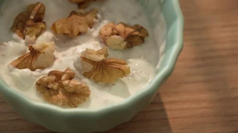 Dolly shot of walnut halves in yogurt oat mix Stock Footage 312708298