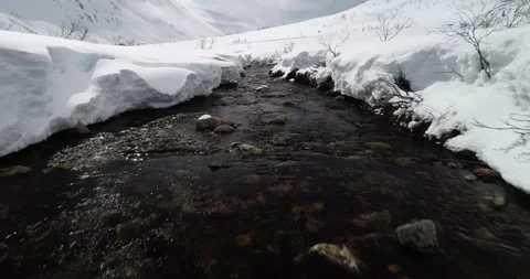 Dolly shot of winter stream or river with snow in arctic Norway Stock Footage 147532756
