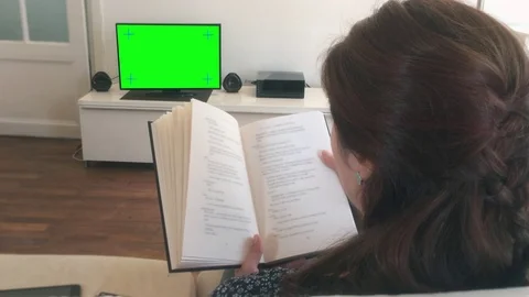 Dolly Shot Woman Reading Book Watching TV Stock Footage