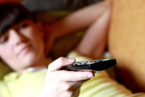 Dolly shot of Woman on a sofa with a tv remote control, dolly, tracking shot Stock Footage