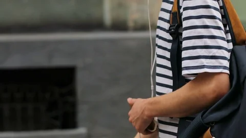 Dolly shot of young man with dreadlocks listening music in smartphone headphones Stock Footage 79438534