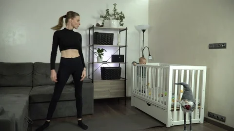 Dolly shot. Young mother performs an exercise at home. 库存影片 125427171