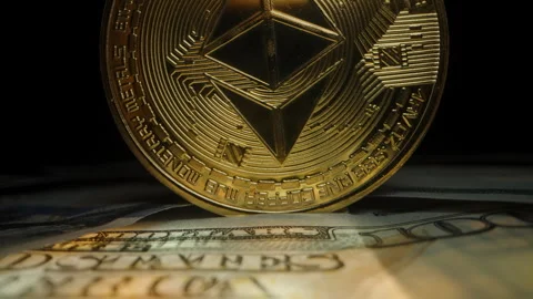 Dolly slider, close up. Golden Ethereum Coin Standing Upright on US Dollar Bills Stock Footage 296560853