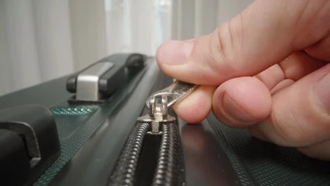 Dolly slider, close up. A Hand pulls the zipper of a suitcase, symbolizing the Stock Footage 282311069