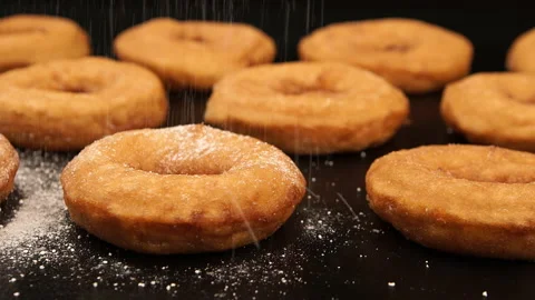 DOLLY: A sugar powder falling on a doughnuts Vídeo Stock 142340372