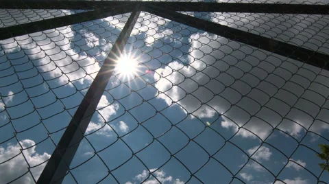 Dolly: Sun shining through the chain link iron wire fencing Stock Footage 40429833