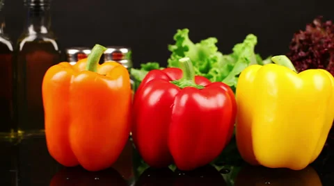 DOLLY: Three varieties of peppers on dark kitchen table Stock Footage 39948455