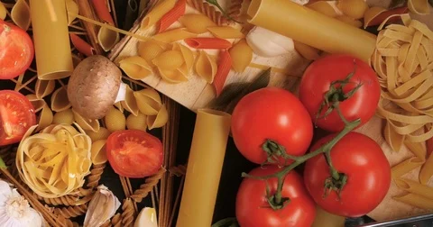 Dolly tilt down view of different variety of Italian pasta and ingredients Stock Footage 71357646