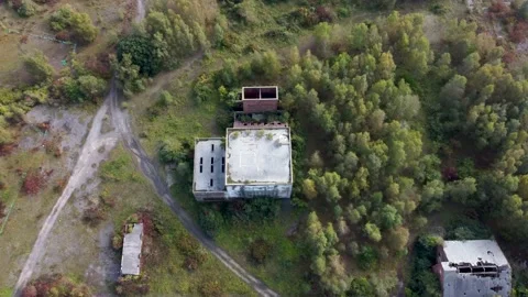 Dolly tilt forward over a large abandoned coal mining building 動画素材 162910618