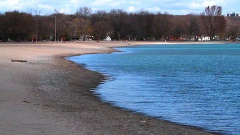 Dolly timelapse wide shot of waves on the shore of a lake Video stock 106038120
