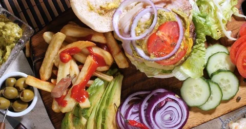Dolly top down view of a delicious cheeseburger with French fries and salad Stock Footage 76444563