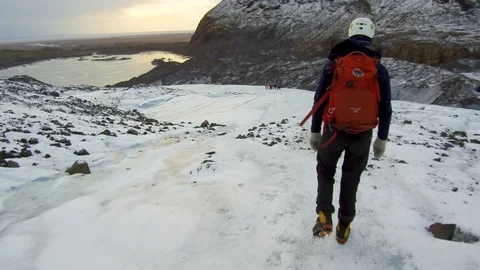 Dolly tracking shot camera follows a lonely mountaineer going down from mountain Stock Footage 94134257