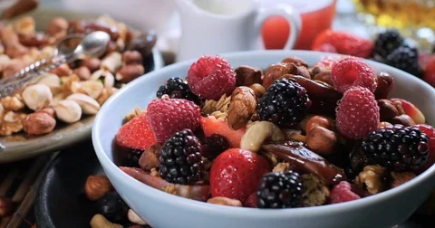 Dolly view of a breakfast of cereals with berries, dry fruits and milk Stock Footage 73138138