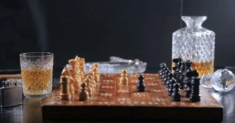 Dolly view: Playing a game of chess with a glass of whiskey and a cigar Stock Footage 74070384