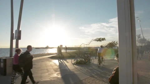Dolly walk forward towards beach sun people pass Stock Footage 169738422