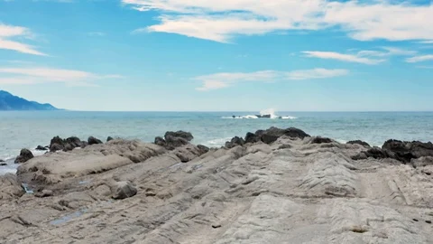 Dolly Zoom of Waves break on rocks in blue ocean. Horizon view of ocean waves Video stock 128282960