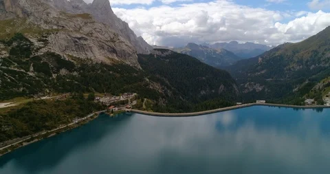 Dolomites dam, C4k aerial, reverse, drone shot, over a lago di fedaia, of a b Stock Footage 99863048