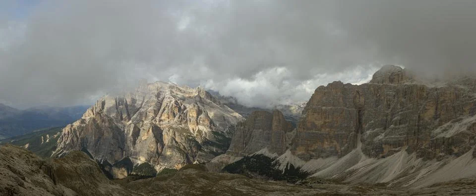 Dolomites dramatic limestone cliffs glowing beneath heavy alpine storm clouds Stock Photos