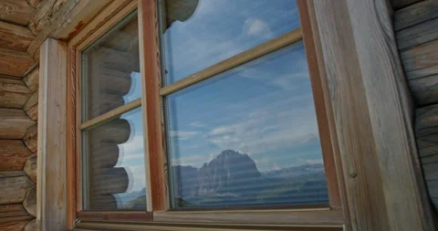 Dolomites mountain landscape reflection in log cabin window Video stock 340781245