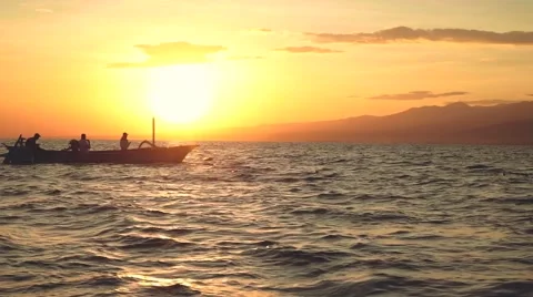 Dolphins jumping in front of boat with 3 people Stock Footage 67707842