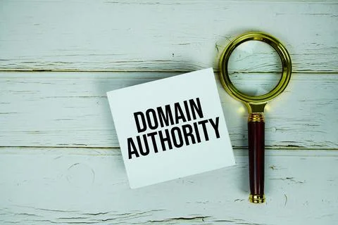 Domain Authority text message on sticky note with magnifying glass on woode.. Stock Photos
