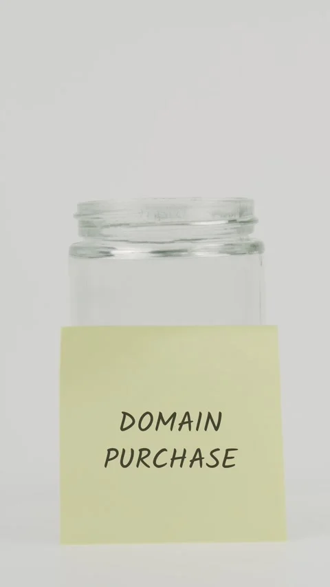 Domain purchase text or word on yellow sticky note attached to glass jar Stock Footage 311721075