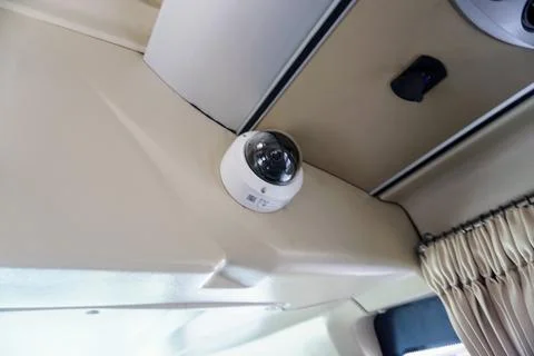 Dome CCTV surveillance camera installed on the interior ceiling of a passenger Stock Photos