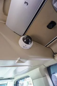 Dome CCTV surveillance camera installed on the interior ceiling of a passenger Stock Photos