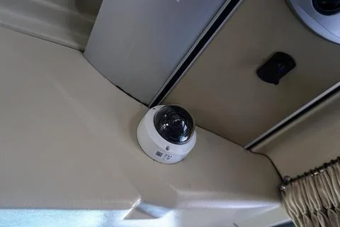 Dome CCTV surveillance camera installed on the interior ceiling of a passenger Stock Photos