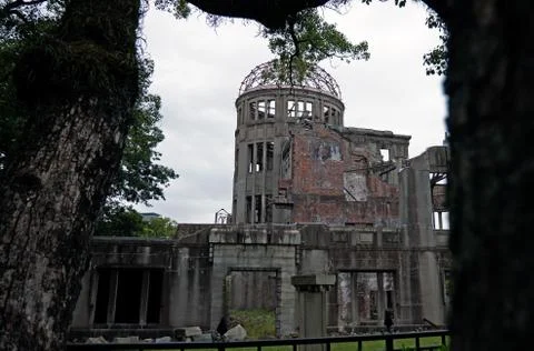 The dome of Hiroshima is visible through some pine tree leaves. Stock Photos