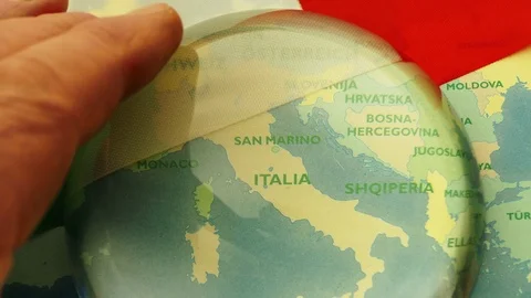 Dome magnifier pushed across a map, highlighting Italy. Stock-Footage 70017759