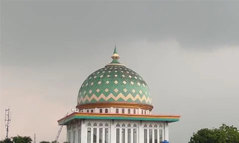 The dome of the mosque is shrouded in overcast clouds. Stock Illustration