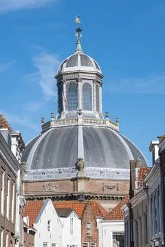 The dome of an old building rises into the blue sky above city buildings Fotos de archivo