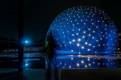 Dome shaped building, with colored lights, reflection in water, parametric .. Fotos de archivo