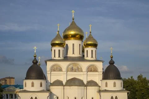 Domes of the Assumption Cathedral in the rays of the rising sun. Dmitrov Kremlin Stock Photos