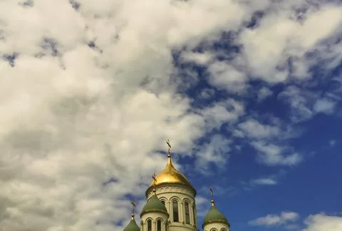 Domes of the temple against the background of a bright blue sky with clouds Fotos de archivo