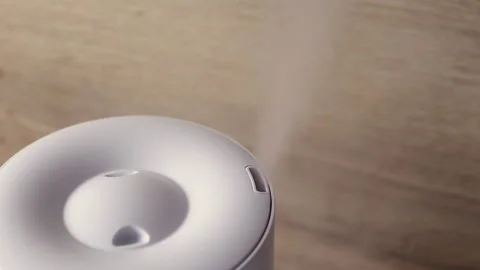 Domestic humidifier spreading steam into the living room Stock Footage
