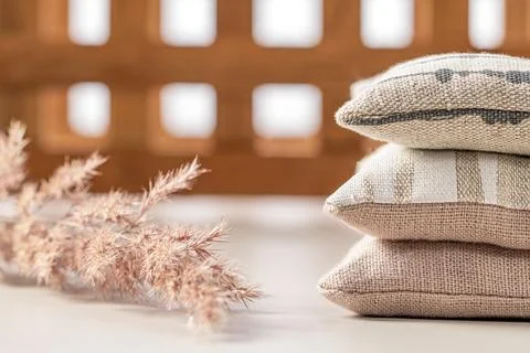 Domestic life. A stack of three pillows, a dry plant stem on a background o.. Stock Photos