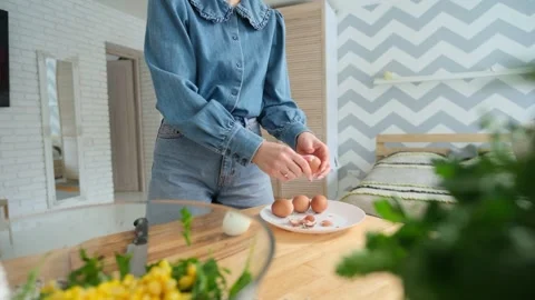 Domesticated woman's hands skillfully peeling boiled brown eggs over a white Stock Footage 345048383