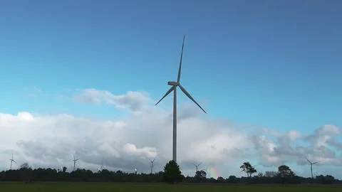 Dominant Wind Turbine Rising Above Treeline with Dramatic Cloud Bank at Auro Stock Footage 334154341