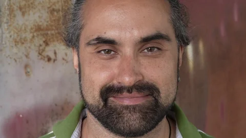A Dominican-looking man with a black beard and mustache smiles sweetly Stock Footage 280176969