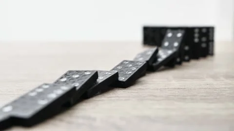 Domino effect in slow motion - falling black tiles with white dots. Dominoes Stock Footage 200891654