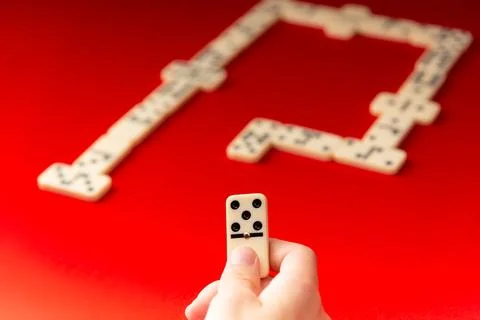 Domino player holding a rectangular acrylic piece. Board game. Foto stock