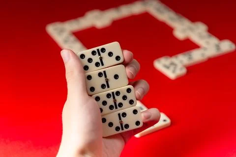 Domino player holding rectangular number acrylic pieces. Board game. Foto stock