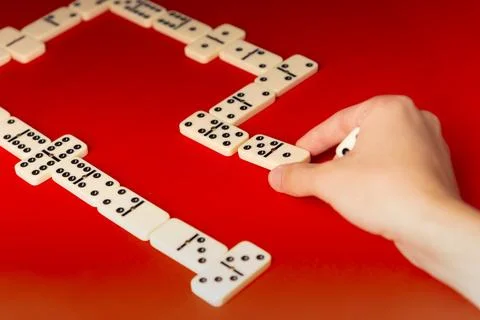 Domino players hand placing a rectangular acrylic tiles. Board game. Stock Photos