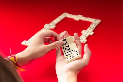 Domino players hands holding rectangular number blocks. Board game. Stock Photos