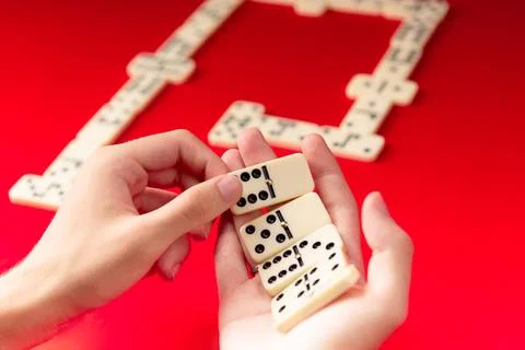 Domino players hands holding rectangular number blocks. Board game. Foto stock
