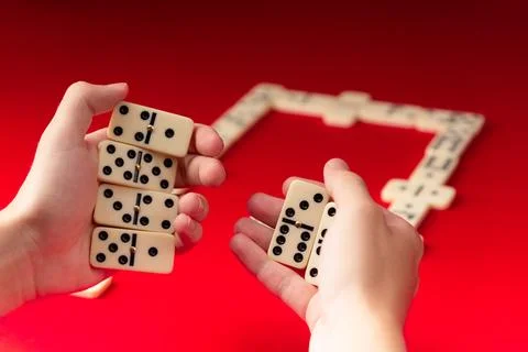 Domino players hands holding rectangular number blocks. Board game. Foto stock
