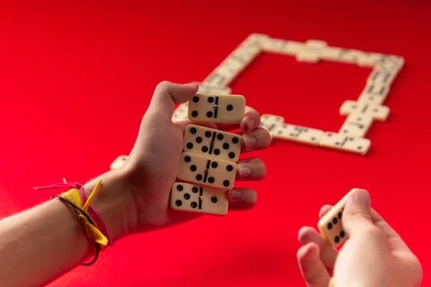 Domino players hands holding rectangular number blocks. Board game. 写真素材